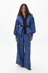 Chaleco azul con estampado a cuadros, con cuello en V y cinturón de terciopelo negro.