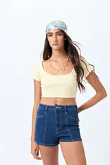 Short de jean de tiro alto, color celeste claro, con bolsillos frontales y traseros, y cierre frontal con botón metálico.