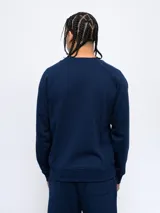 Buzo gris melange de felpa sin frisa, con cuello redondo y logo de Umbro bordado en azul marino en el pecho.