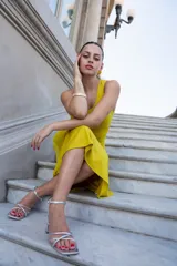 Vestido midi mostaza de un hombro con abertura lateral en la cintura.