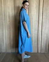 Vestido túnica celeste de lino con rayas verticales blancas, corte recto, cuello camisero y mangas cortas.
