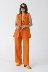 Pantalón de vestir naranja, de corte palazzo y tiro alto.