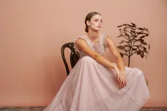 Vestido largo de fiesta color rosado con lunares blancos. Tiene cuerpo de micro tul bordado con volados en los hombros y falda de tul con forro. Incluye cinturón de raso al tono.