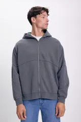 Campera deportiva gris oscuro con cierre frontal, capucha y corte holgado.