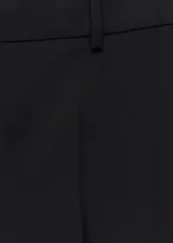 Pantalón de vestir negro de corte recto, tiro alto y tejido de mezcla de lana con forro interior. Cuenta con trabillas, bolsillos laterales y traseros de ribete. Cierre frontal oculto con botón, gancho y cremallera.