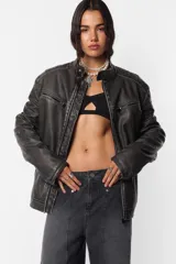 Chaqueta de cuerina pu opaca efecto vintage gastada, de silueta “oversize”. Acceso delantero mediante cierre metálico desmontable color dark niquel, con cartera interna pespunteada en zig zag de misma tela base. Cuello mao con snap y hombreras matelaseadas. Bolsillos delanteros con cierre metálico dark niquel Los ubicados en la parte superior son falsos. Terminación en manga con cierre metálico dark niquel para ajustar puño Por su interior, forrería matelaseada y bolsillo oculto en lado izquierdo superior con cierre invisible.