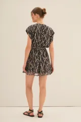 Vestido corto con estampado floral multicolor, escote en V, mangas cortas y cinturón ancho negro con aplique de flor.