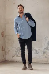 Camisa celeste de corte clásico, manga larga y cuello abotonado.