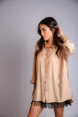 Camisa celeste de corte clásico, con botones frontales y bordados florales en las mangas.