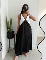 Vestido largo de corte amplio, con breteles finos y escote en V. La parte superior es blanca y la falda es negra.