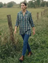 Camisa de manga larga con estampado de cuadros en tonos verde, azul marino y amarillo. Presenta un canesú bordado en la parte superior del pecho y hombros con diseño geométrico en tonos verdes y blancos.