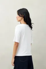 Remera de modal color marrón claro, de manga corta, con cuello asimétrico y detalle de nudo con frunces.