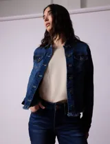 Campera de jean azul de la marca Baccini, con cuello solapa, abertura central con botones metálicos, bolsillos delanteros y ruedo desflecado.