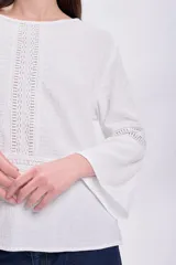 Blusa de muselina color crudo, de corte recto, con cuello redondo y mangas largas acampanadas con detalle de vainillas.