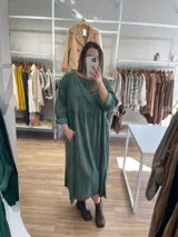 Vestido largo de pana fina color verde con estampado de flores marrones, corte oversize, mangas 3/4 y bolsillos laterales.