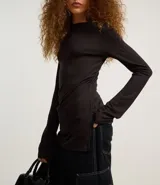Blusa femenina ajustada, confeccionada en malla rib de viscosa, con cuello alto y mangas largas. Sin estampa y posee fruncido en los laterales.