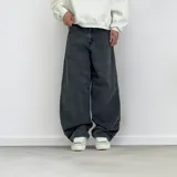 Pantalón jean negro de corte ultra baggy, con bolsillos traseros y etiqueta de marca en la cintura.