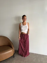 Pollera larga de fibrana color bordó con estampado de lunares blancos.