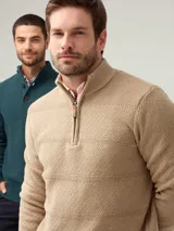 Buzo tejido texturado color beige, con cuello alto y cierre frontal parcial con detalle de cuero.