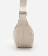 Bolso bandolera mediano color beige con textura drapeada y correa ajustable.