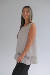 Musculosa beige amplia de lino italiano, con terminaciones delicadas y franja de encaje en el ruedo.