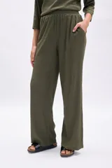 Pantalón de mujer color verde militar, de tiro alto y corte ancho (wide leg), confeccionado en tela con textura acanalada o plisada.
