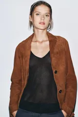 Blazer marrón de ante con cuello de solapa de muescas, manga larga, bolsillos de parche delanteros y cierre frontal con botones.