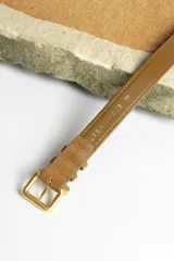 Cinturón marrón de gamuza con hebilla dorada.