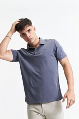 Remera polo azul grisáceo de estilo jersey, corte regular y logo estampado en el pecho.