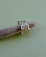 Anillo plateado con textura irregular y diseño rústico.