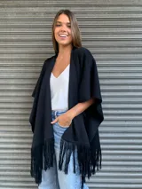 Ruana negra con apliques de cuero y flecos.