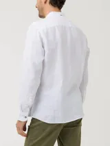 Camisa blanca de lino orgánico con cuello mao, manga larga y cierre frontal con botones de madera.
