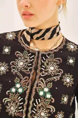 Saco corto negro, ajustado al cuerpo, con escote redondo y bordado a mano en frente, espalda y mangas con lentejuelas y pedrería en forma de estrellas y motivos florales.