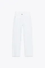 Jeans tobilleros de tiro alto color blanco, corte recto y bajo sin costura. Cierre frontal cruzado con cremallera y botones.