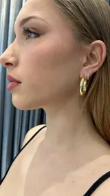 Aros tipo argolla gruesa, color dorado, con cierre a presión.