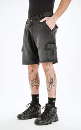 Bermuda de denim negra con corte a la rodilla, estilo cargo con bolsillos laterales y traseros con solapa. Diseño clásico de cinco bolsillos y ruedo desflecado. Confeccionada en denim rígido 100% algodón.