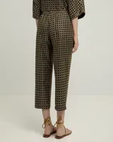 Pantalón recto negro con estampado geométrico dorado, confeccionado en algodón con bordado de poliéster.