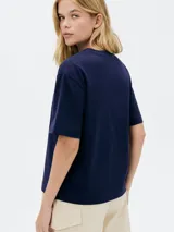 Remera color crema de corte amplio con estampa de un pescado y texto en azul marino.