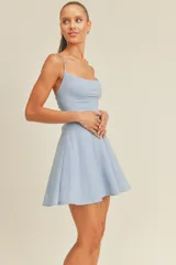 Vestido corto celeste con breteles finos y falda acampanada.