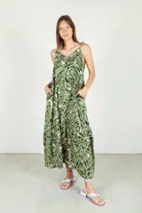 Vestido largo verde con estampado abstracto en blanco y negro, de fibrana, con breteles finos y volado en el ruedo.