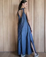 Vestido largo azul melange de corte imperio, con escote en V y breteles finos. Presenta una abertura lateral en la falda.
