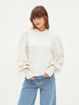 Sweater color gris melange, de tejido de punto, con cuello redondo y mangas abullonadas.
