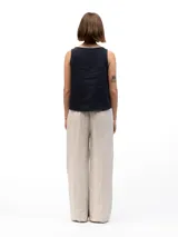 Pantalón de lino beige de corte holgado, con cintura elástica, dos bolsillos laterales y un bolsillo trasero.