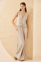 Chaleco color beige con botones decorativos con forma de ananá.