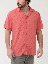 Camisa celeste con estampado de peces negros, de manga corta y corte recto.