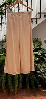 Pantalón de corte piyamero, con cintura ancha elastizada, bolsillos aplicados en la parte trasera y detalles en hilo al tono.