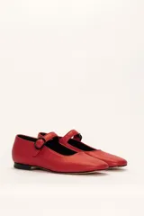 Zapato estilo Mary Jane color marrón, de cuero, con punta redondeada y tira sobre el empeine con hebilla.