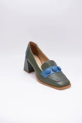 Zapato de cuero negro con aplique plateado y botones forrados en cuero.