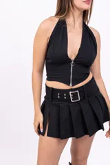 Minifalda negra plisada con cinturón con hebilla plateada y abertura lateral.