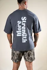 Remera gris con estampado en el frente con la frase "Fear Less". En la espalda tiene un estampado vertical con la frase "More Strength".